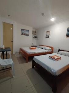 a room with two beds and a table and a chair at RenSea Haven Boracay in Boracay