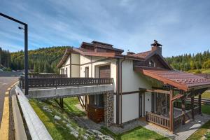 a small house with a bridge next to a road at Cristal Garden Chalet in Bukovel