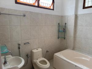 a bathroom with a toilet and a sink at KmK Homestay in Rupa