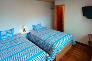 two beds sitting next to each other in a room at Casa San Andres Hostal in Pasto
