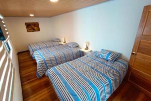 two beds in a small room with two lamps at Casa San Andres Hostal in Pasto +5 photos