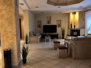 a living room with a couch and a television at Hotel Isidora in Loutrós