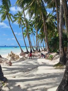 a group of people on a beach with palm trees at RenSea Haven Boracay in Boracay