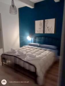 a bed in a room with a blue wall at Irisapartment in Reggio di Calabria