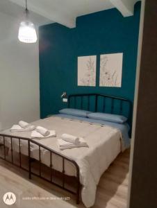 a bedroom with a bed with a blue wall at Irisapartment in Reggio di Calabria