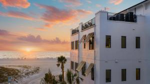 a white building on the beach with a sunset at The Pearl in Clearwater Beach +52 photos