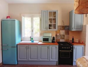 a kitchen with a blue refrigerator and a microwave at El nido del dragón in Carratraca