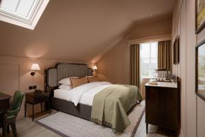 a bedroom with a bed and a desk and a window at The Kithmore in St. Andrews +29 photos