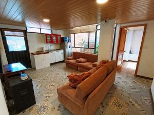 a living room with a couch and a kitchen at Casa San Andres Hostal in Pasto