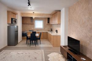 a kitchen with a table and chairs and a refrigerator at Dialb Apartments in Debar