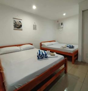 two twin beds in a room withthritisthritislictslicts at RenSea Haven Boracay in Boracay +39 photos