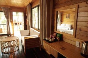 a room with a bedroom with a bed and a mirror at The Lake Hill Farm Tà Đùng in Biđong