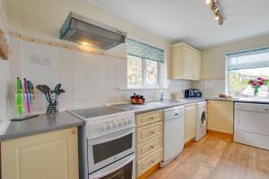 a kitchen with white appliances and wooden floors at 3 Bed in Sennen Cove oc-p00781 in Sennen