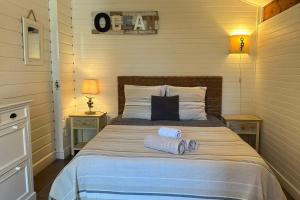 a bedroom with a bed with two towels on it at chalet with swimming pool in leisure park in Gujan-Mestras
