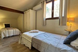 a bedroom with two beds and a window at chalet with swimming pool in leisure park in Gujan-Mestras
