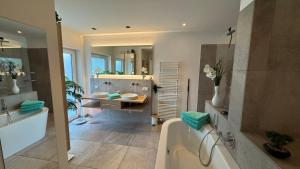 a bathroom with a tub and a sink at Exklusives Architektenhaus, Pool und Privateinfahrt in Mönchengladbach