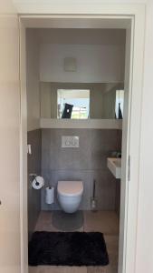a small bathroom with a toilet and a sink at Exklusives Architektenhaus, Pool und Privateinfahrt in Mönchengladbach