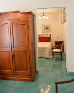 a bedroom with a bed and a wooden cabinet at Donna Alda Affittacamere Capitello dal 2012 in Villammare