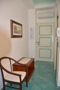a room with a chair and a table and a door at Donna Alda Affittacamere Capitello dal 2012 in Villammare