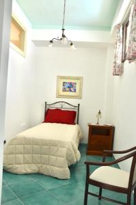 a bedroom with a bed with a red pillow and a chair at Donna Alda Affittacamere Capitello dal 2012 in Villammare +43 photos