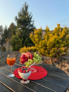 a table with a bowl of fruit and a glass of wine at Natalii in Kudowa-Zdrój