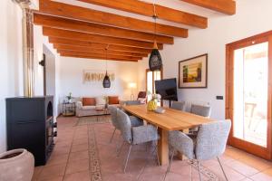 a living room with a wooden table and chairs at Idyllische Natur-Finca mit 12m Pool & Meerblick in Porto Cristo
