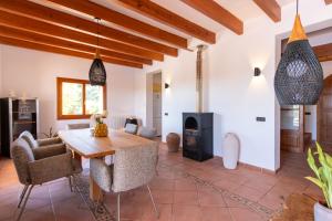 a living room with a wooden table and a fireplace at Idyllische Natur-Finca mit 12m Pool & Meerblick in Porto Cristo