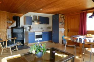 a kitchen with blue cabinets and a table in a room at Ferienwohnung Stirnimann-Gemsch in Valzeina