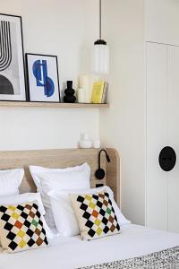 ein Schlafzimmer mit einem Bett mit weißen Laken und Kissen in der Unterkunft Le Riviera Collection, Signature Collection by Best Western in Nizza