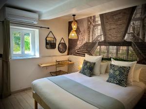 a bedroom with a bed in a room with stairs at Hôtel Le Clos du Dramont in Saint-Raphaël