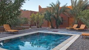 a swimming pool in a yard with chairs and trees at Casa Juan in Tagounite