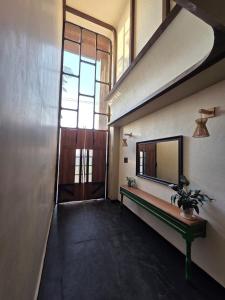 a hallway with a door and a table and a mirror at ANVI Homestay in Bhopal