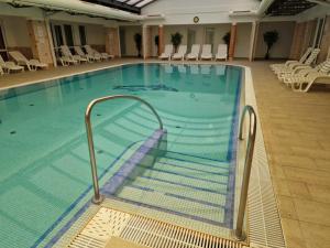 a large swimming pool with a ramp in a building at Fiore Wellness Apartman in Zalakaros