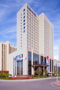 a large white building with a sign on it at Novotel Daqing Haofang in Daqing