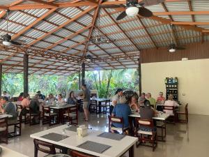 a group of people sitting at tables in a restaurant at Orquideas Boutique Hotel in Fortuna