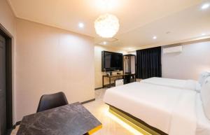 a hotel room with a bed and a desk and a tv at Masan First Class Hotel in Changwon