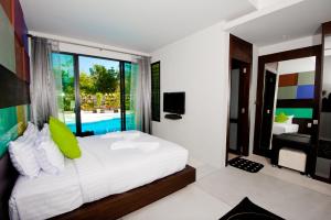Un dormitorio con una cama y vistas a una piscina. en Chalay Monta, en Hua Hin