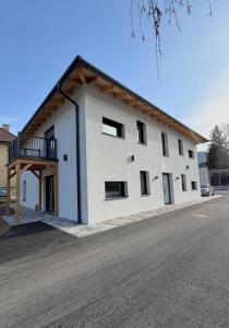 a white building with a balcony on the side of a street at Pollross Apartments in Reichenau