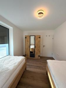 a bedroom with two beds and a large window at Pollross Apartments in Reichenau