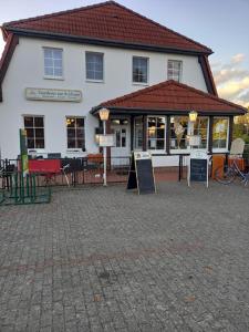 a large white building with signs in front of it at Gasthaus Zur Schleuse Canow in Wustrow