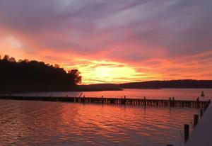 a sunset over a body of water with a dock at Gasthaus Zur Schleuse Canow in Wustrow