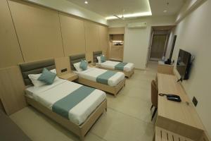 a hotel room with two beds and a television at Sarju Palace in Valsād