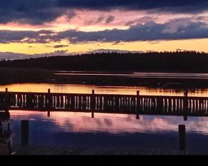 a sunset over a body of water with a dock at Gasthaus Zur Schleuse Canow in Wustrow