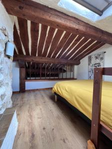 a bedroom with a bed and a stone wall at Le Gite des Anges du Verdon in Trigance