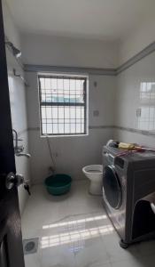 a bathroom with a washing machine and a toilet at Konjyosom Homestay-Experience Real Nepali Hospitality in Kathmandu