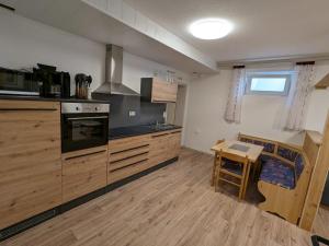 a kitchen with wooden cabinets and a table in it at Souterrainwohnung in Kelheim