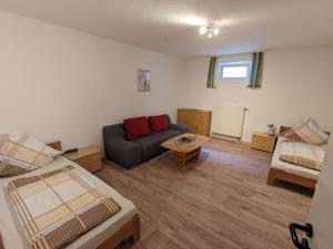 a living room with a couch and a table at Souterrainwohnung in Kelheim