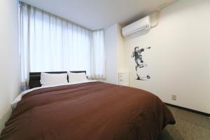 1 dormitorio con 1 cama con monopatín en la pared en Roots Hostel, en Osaka