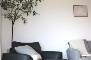 a living room with two chairs and a tree at Rowan Beg Retreat Lake View Apartment in Renvyle