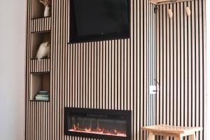 a wall with a fireplace with a tv on it at Rowan Beg Retreat Lake View Apartment in Renvyle +35 photos